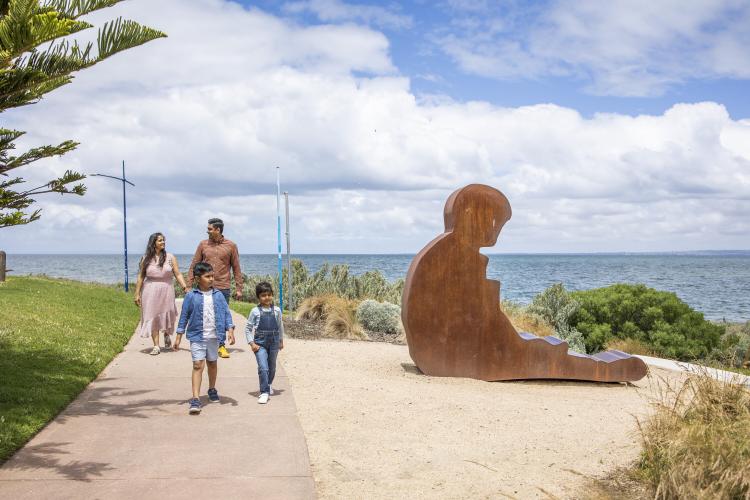 Image 1: family walking beside sculpture